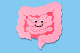 A pink cartoon image of a colon with a smiley face on it represents colonoscopy prep hacks for a better experience.