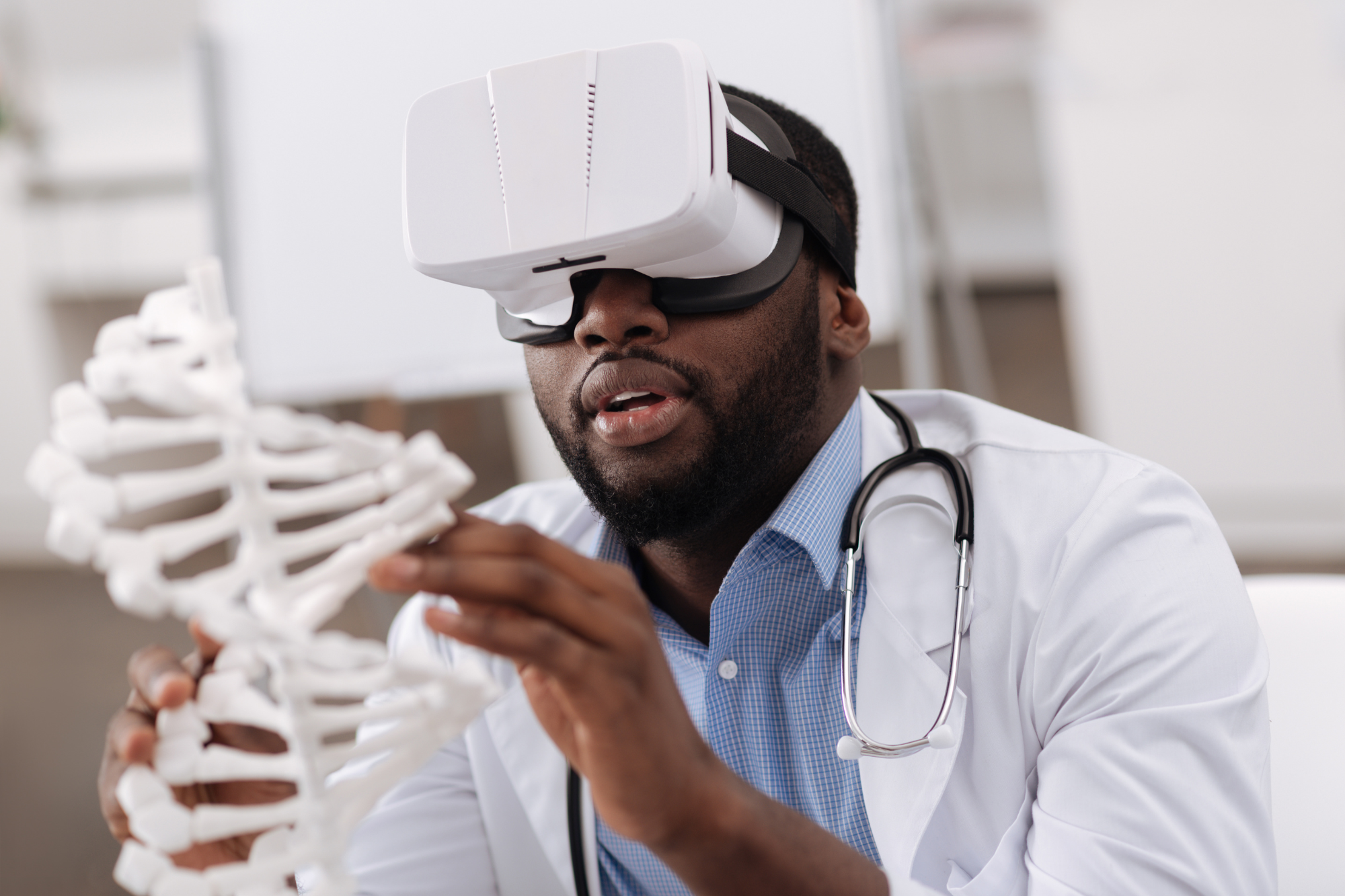 A doctor implements innovation in his medical practice by using AR technology to analyze a model double helix.