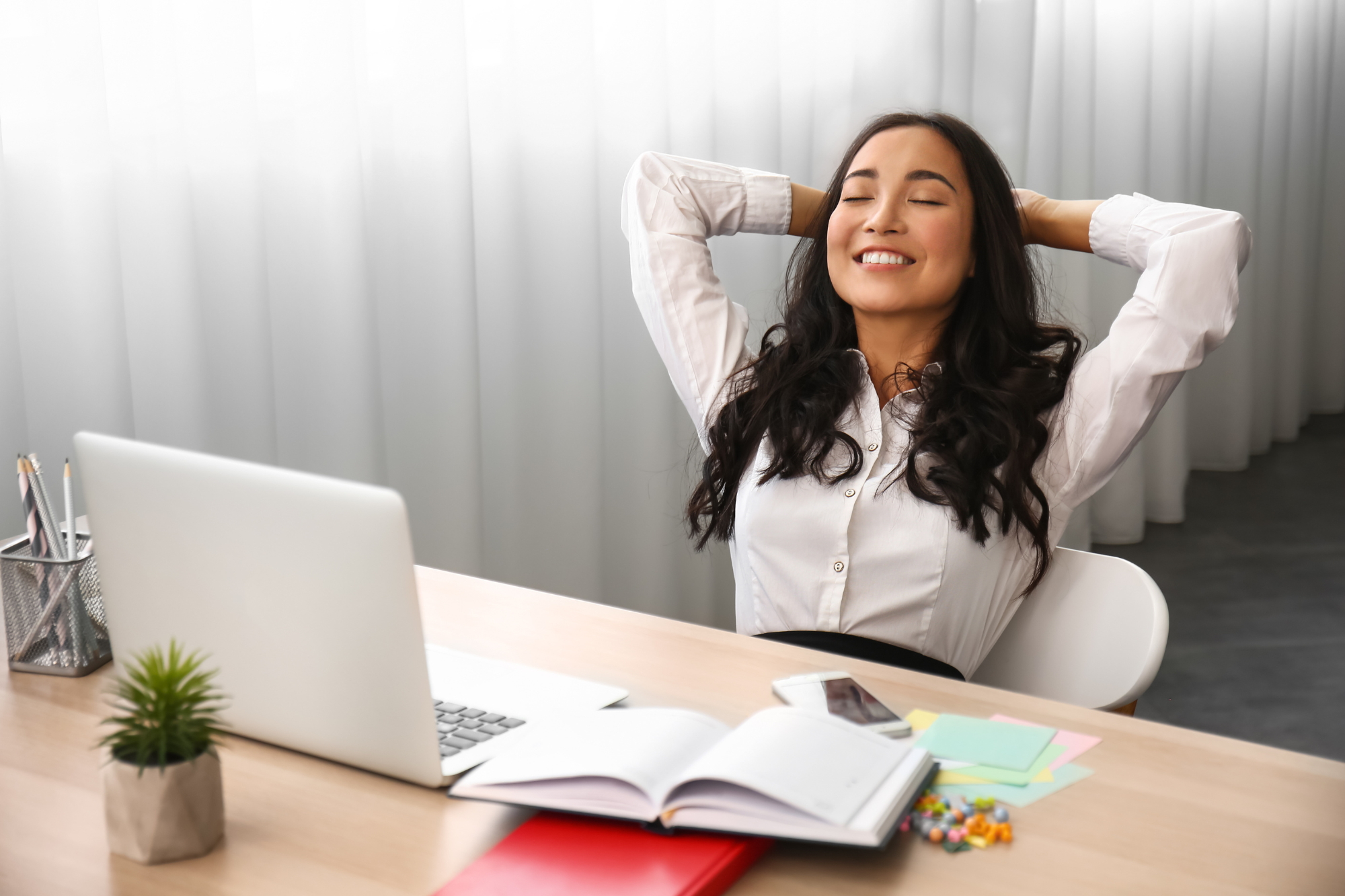 A woman relaxing at desk with laptop, demonstrating parasympathetic nervous system balance while maintaining productivity.