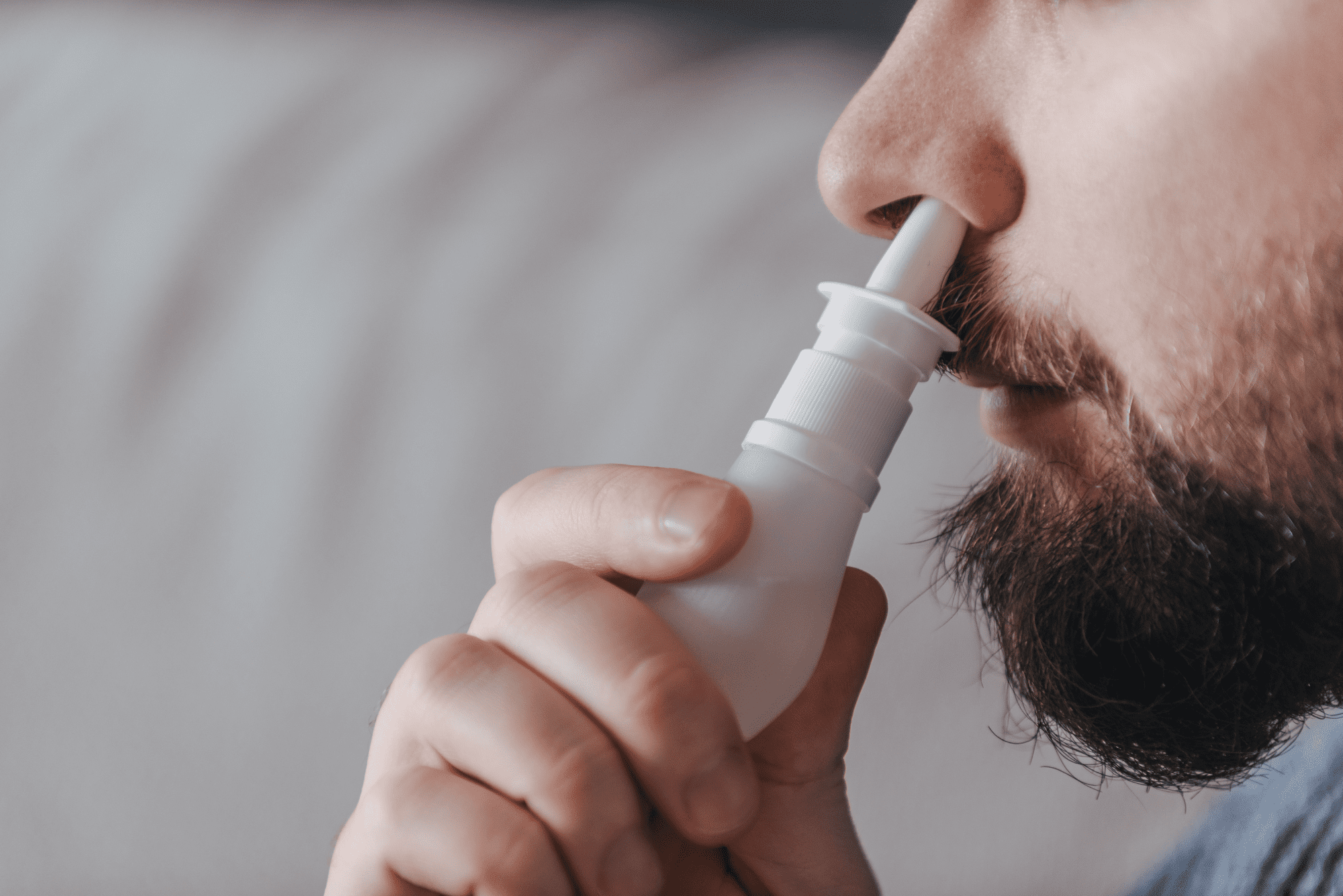 Man using nasal spray for congestion relief.