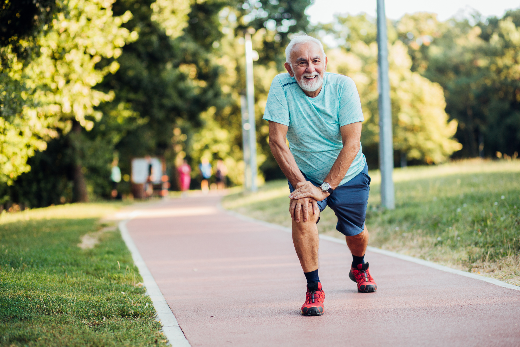 An older man stretching outdoors, preparing for a run.