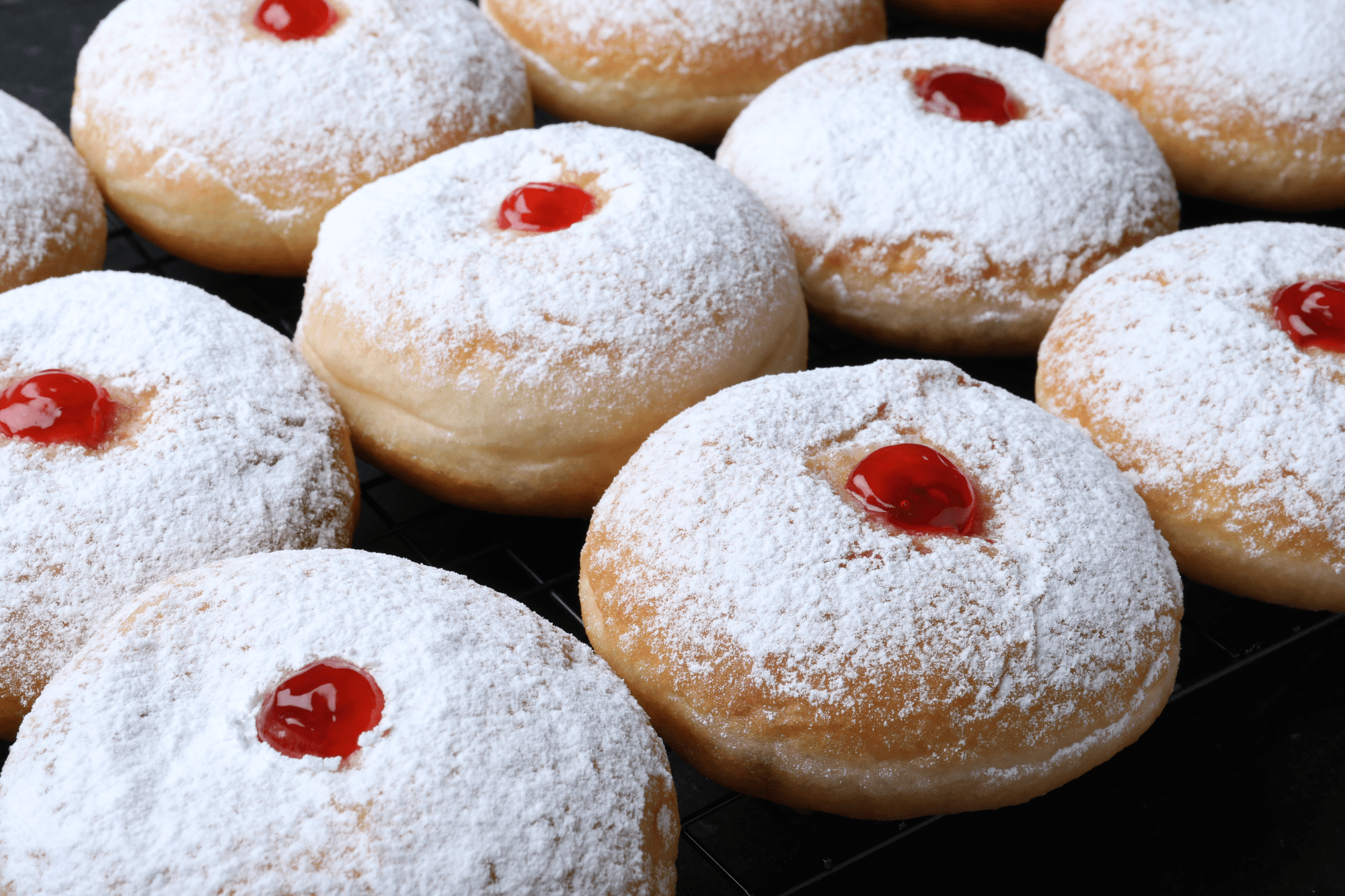 Close-up of powdered sugar jelly donuts with glossy red jam, symbolizing PSA testing time for accurate results.