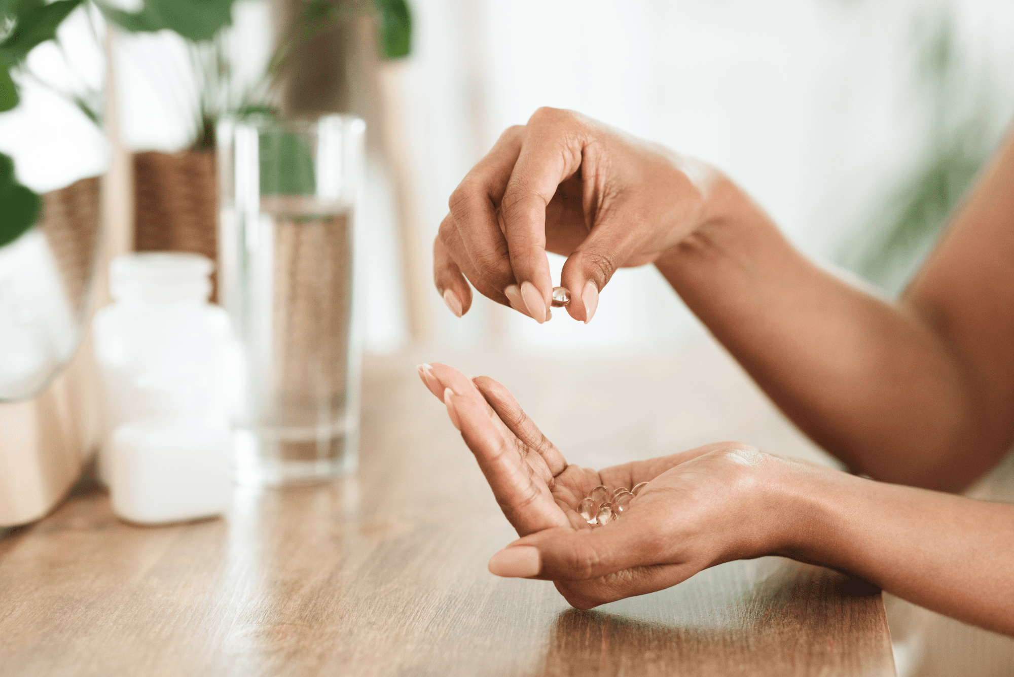 A woman holds supplement capsules in her palm in a soft.